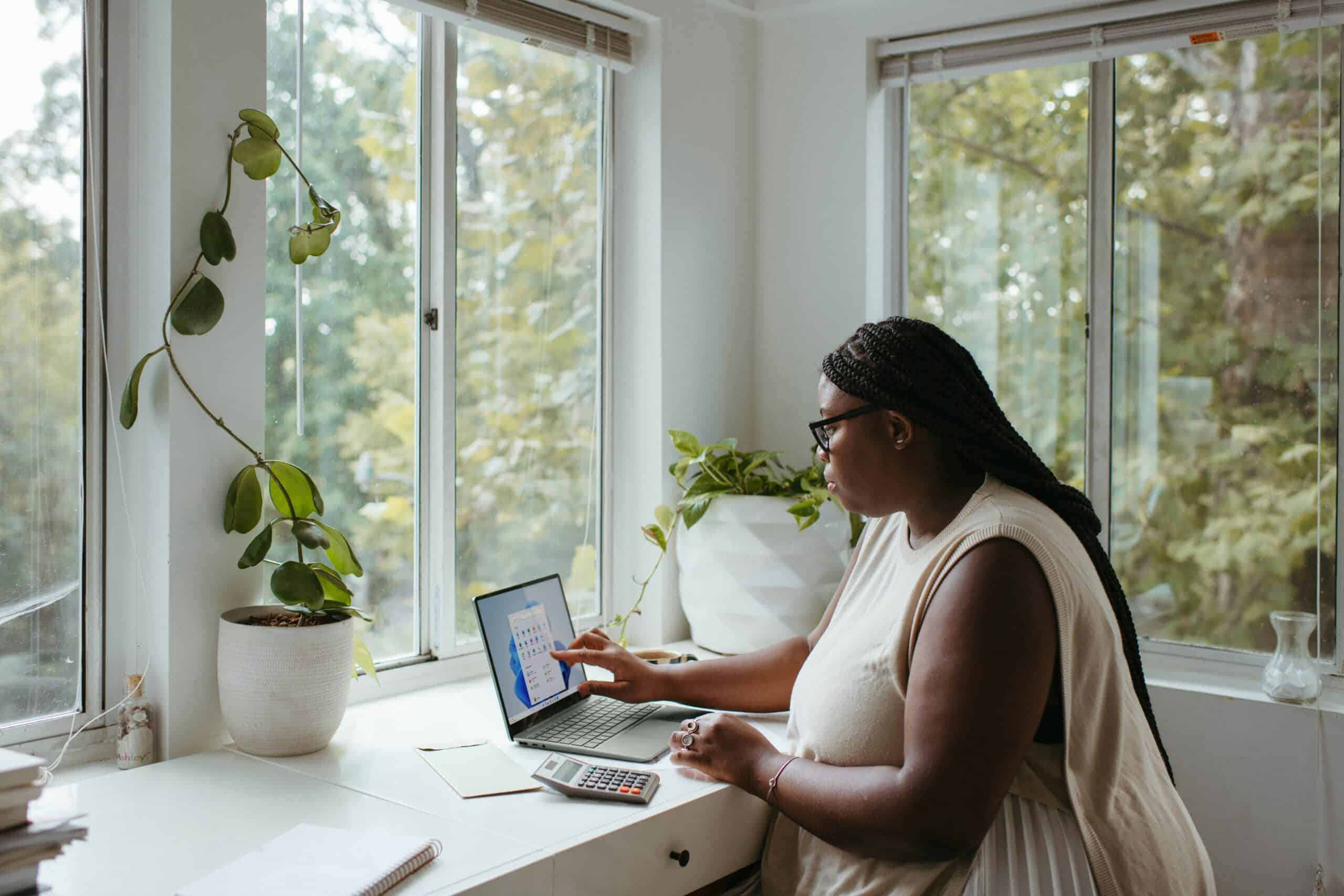 African American woman in a white blouse working at a home office