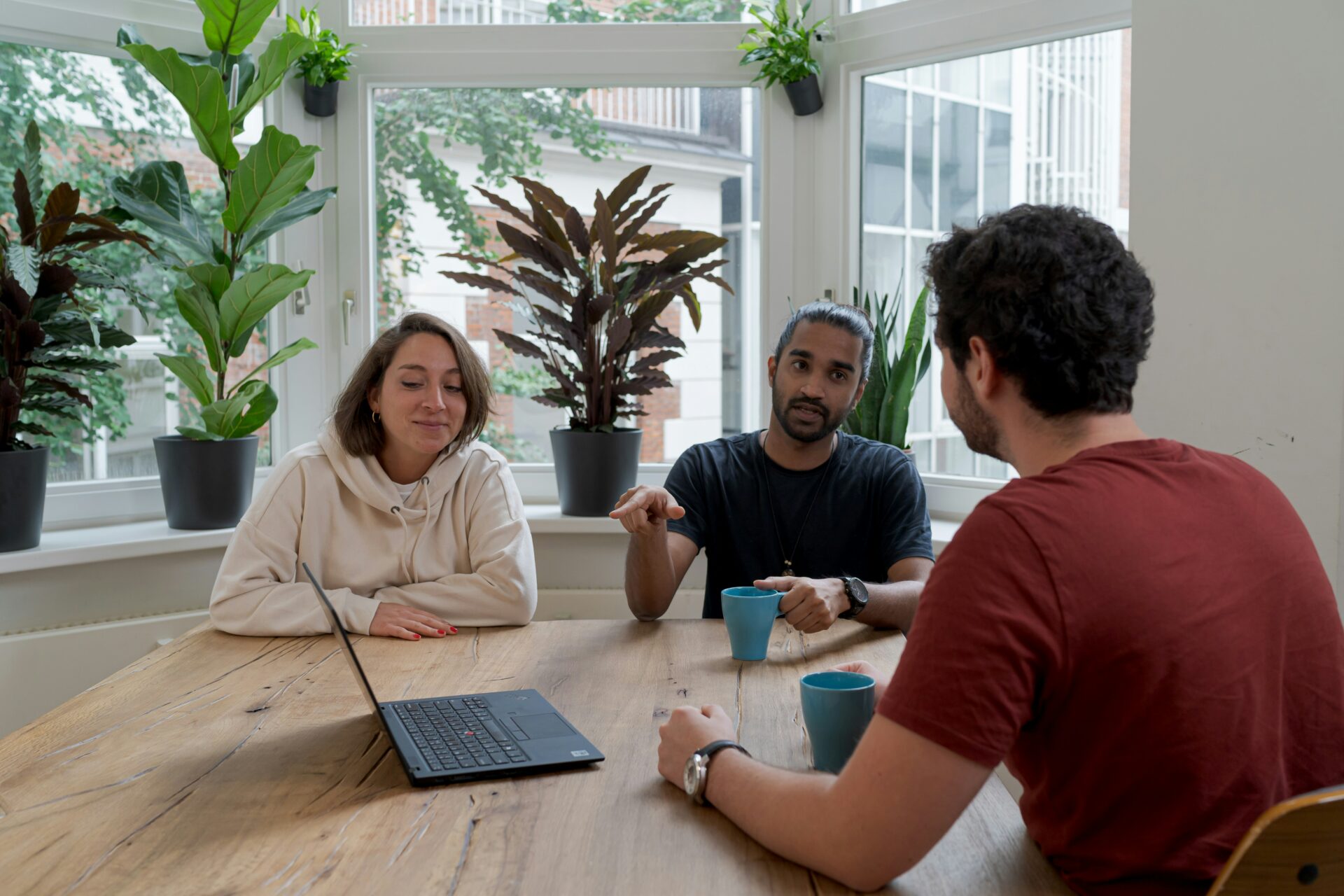 Three people sitting around a laptop