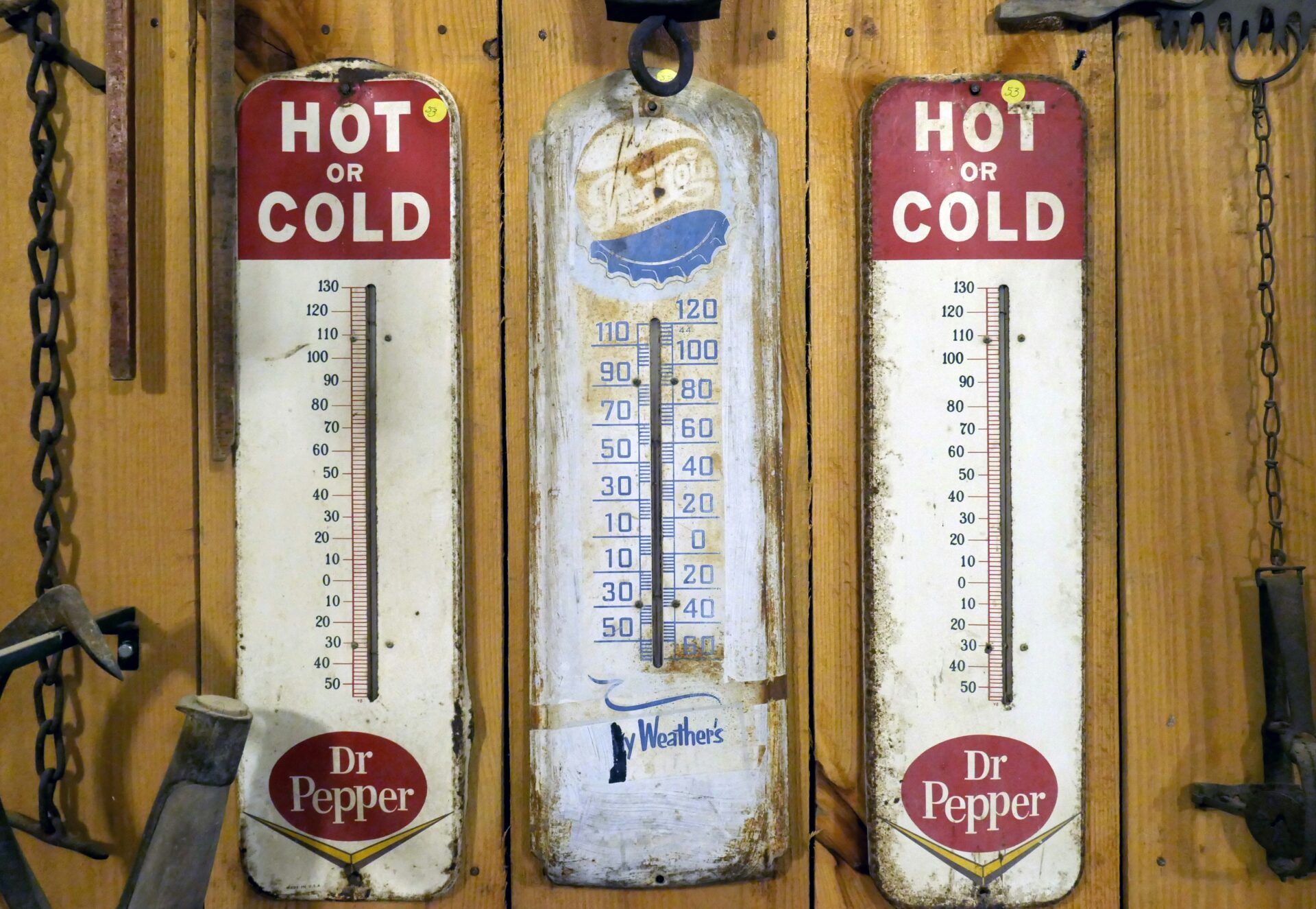 Three old thermometers. One is Pepsi branded, the other two are Dr. Pepper branded.