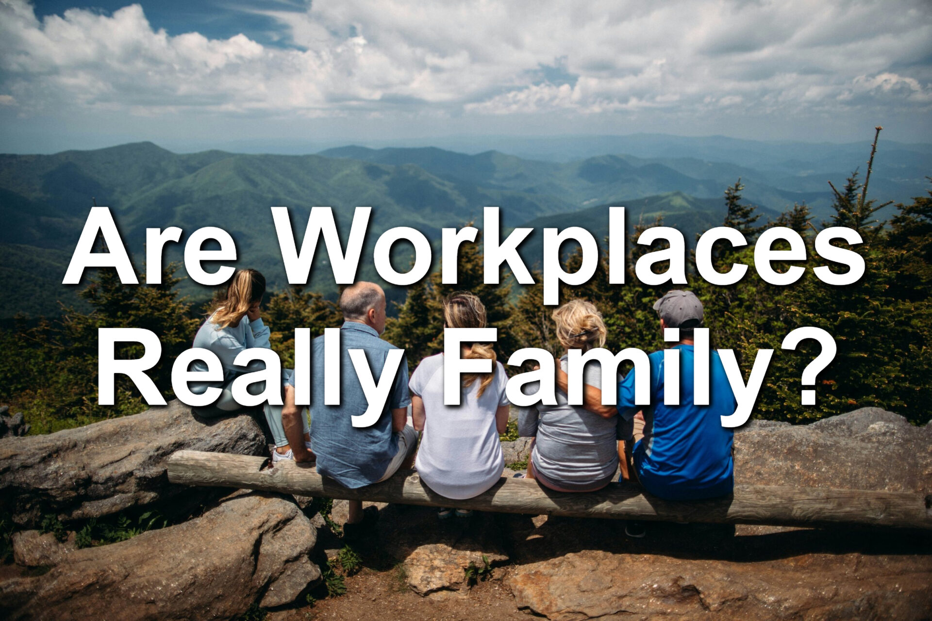 A family sitting on a fallen tree in a desert