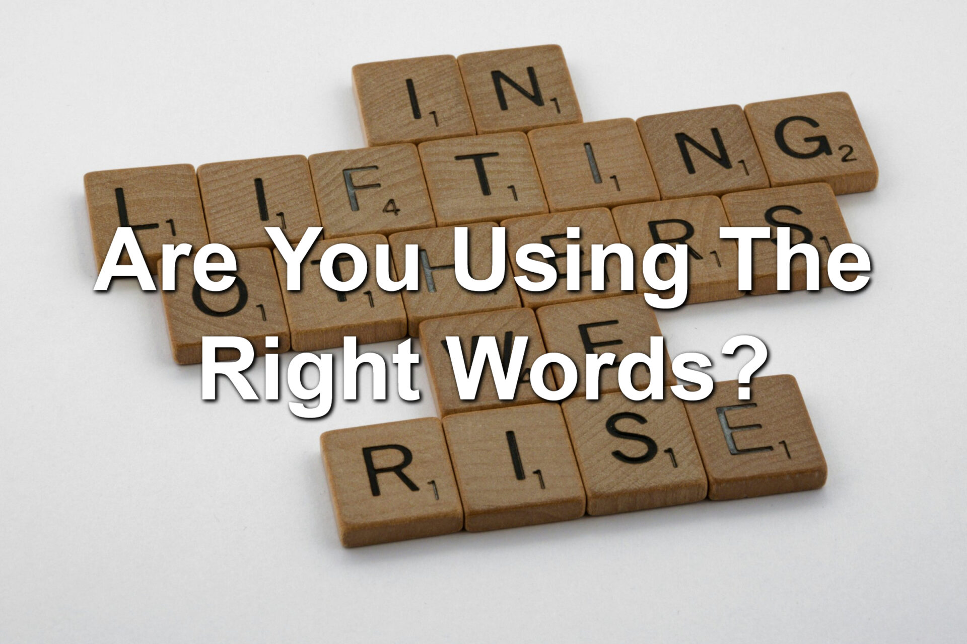 Scrabble tiles forming the words: In lifting others, we rise