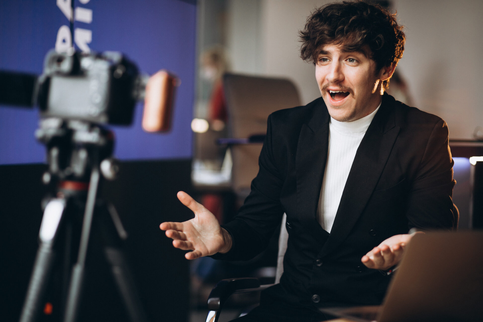 Young man in a suit in front of a video camera