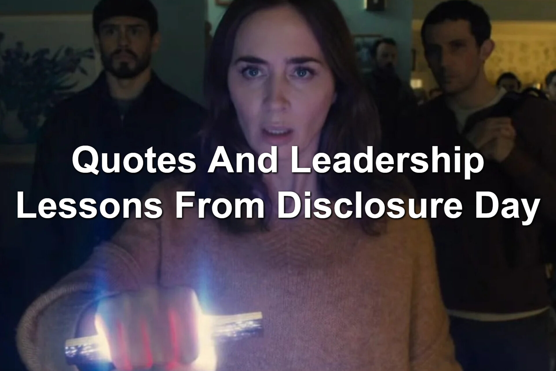 People standing behind a woman. She's holding a glowing object in her hand. Scene from Disclosure Day.
